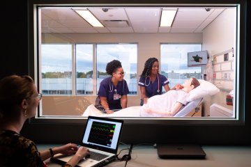 Nursing students in a lab with mannequin