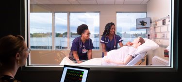 Nursing students in a lab with mannequin