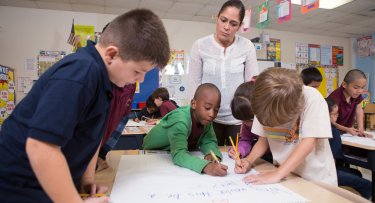 Kindergarten teacher watching her class at work.