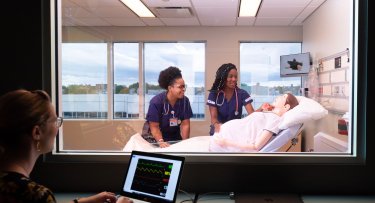 Nursing students in a lab with mannequin