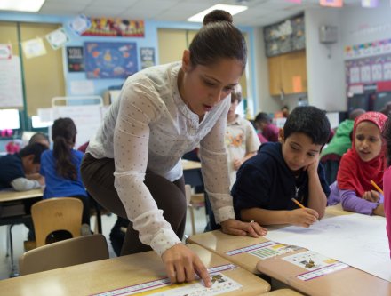 Kindergarten teacher working with students.