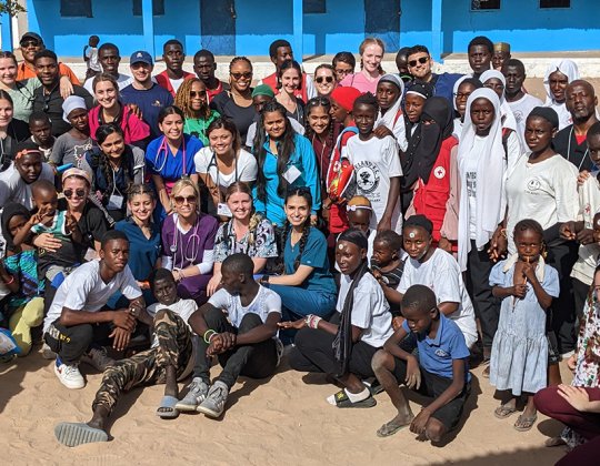 Mercy students and faculty with residents of a village in The Gambia